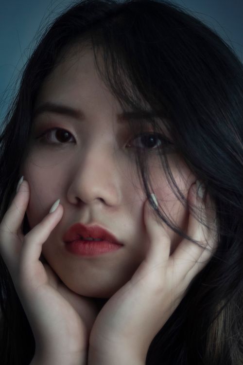 Free Dramatic close-up portrait of a woman with thoughtful expression, highlighting beauty and elegance. Stock Photo