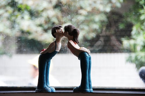 Free Close-up of Kissing Figurines by a Glass Window Stock Photo