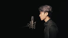 Side View of a Man in Front of a Condenser Microphone