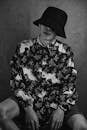 Grayscale Photo of a Man in a Bucket Hat and a Printed Shirt