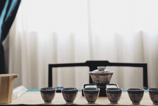 A beautifully arranged tea set on a table with soft natural lighting and a blurred background.
