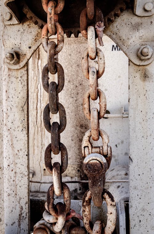 Weathered rusty chain on metal fence