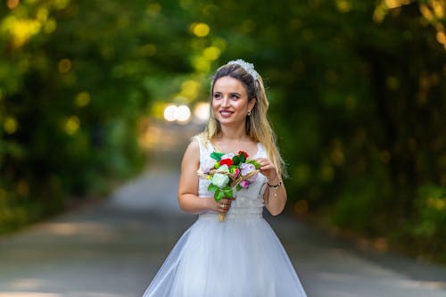 A Beautiful Woman in White Wedding Dress Holding a Bouquet of Flowers