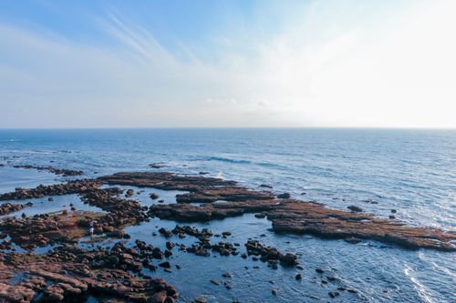 Free A breathtaking aerial view of the rocky coastline of São Pedro da Cadeira, Portugal, with serene ocean expanse. Stock Photo