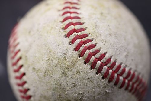 Free Detailed close-up of a worn baseball showcasing red stitching on its surface. Stock Photo