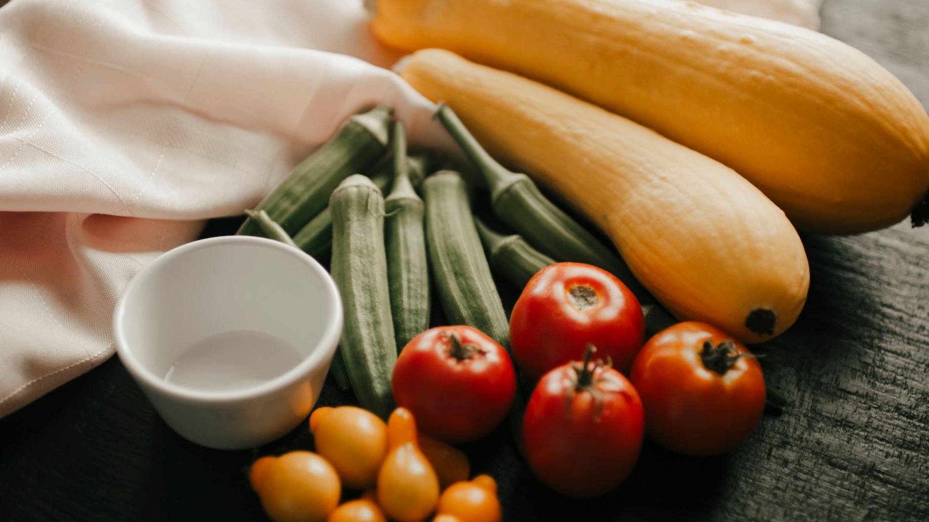 Fresh okra and tomatoes in a cooking pan