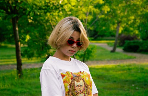 Free A Woman in Trendy Sunglasses at a Park Stock Photo