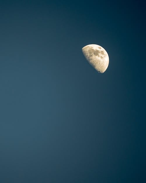 Half moon against dark blue sky at night