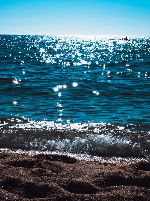 Shiny blue seawater near sandy beach