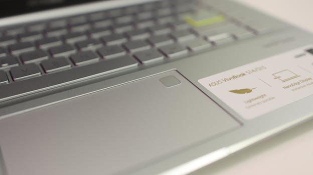 Detailed close-up of a laptop's touchpad and keyboard with branding visible.