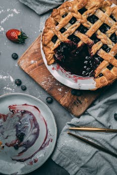 Mouth-watering homemade blueberry pie in a beautiful flat lay setting.