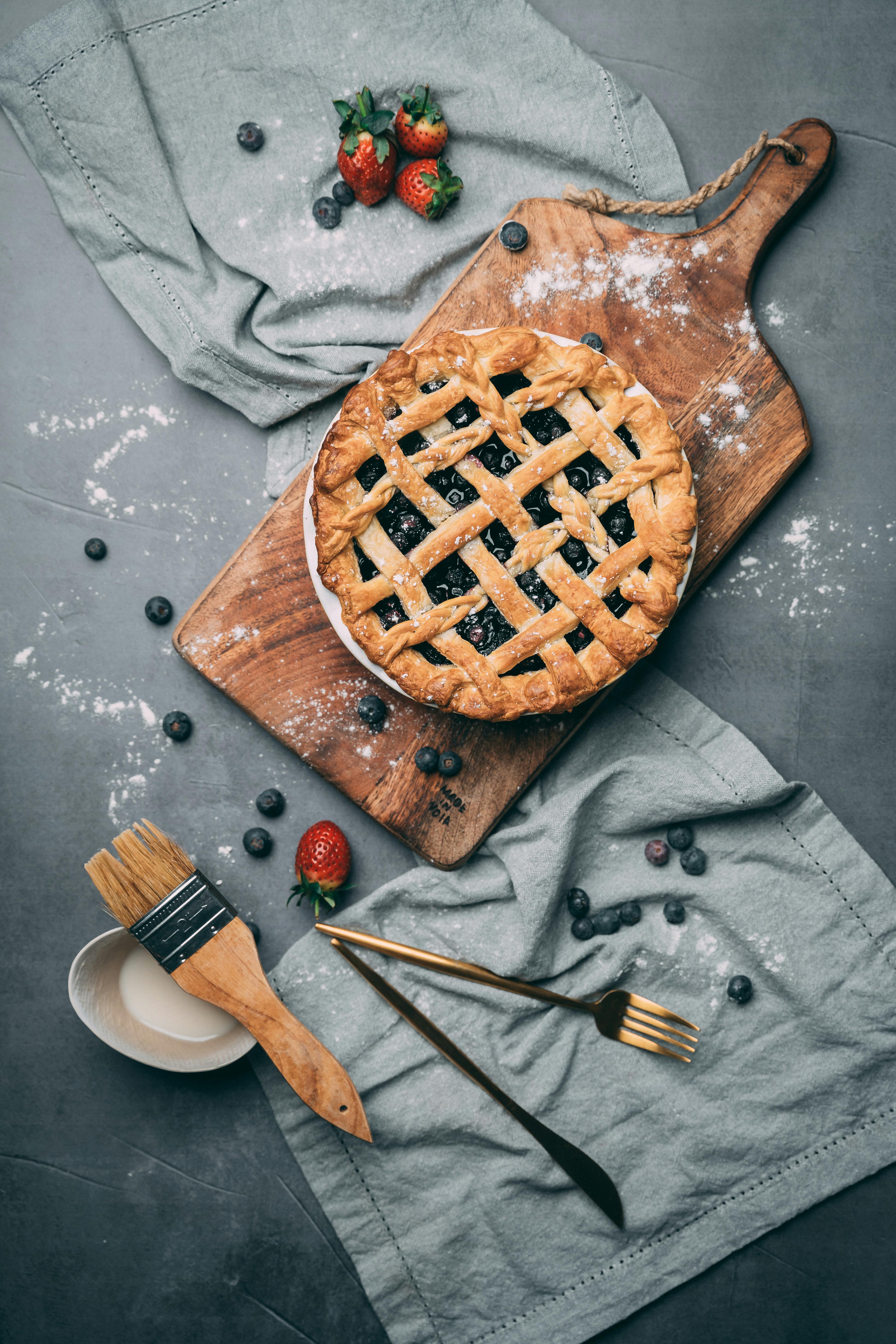 photo of berry pie on top of wooden chopping board