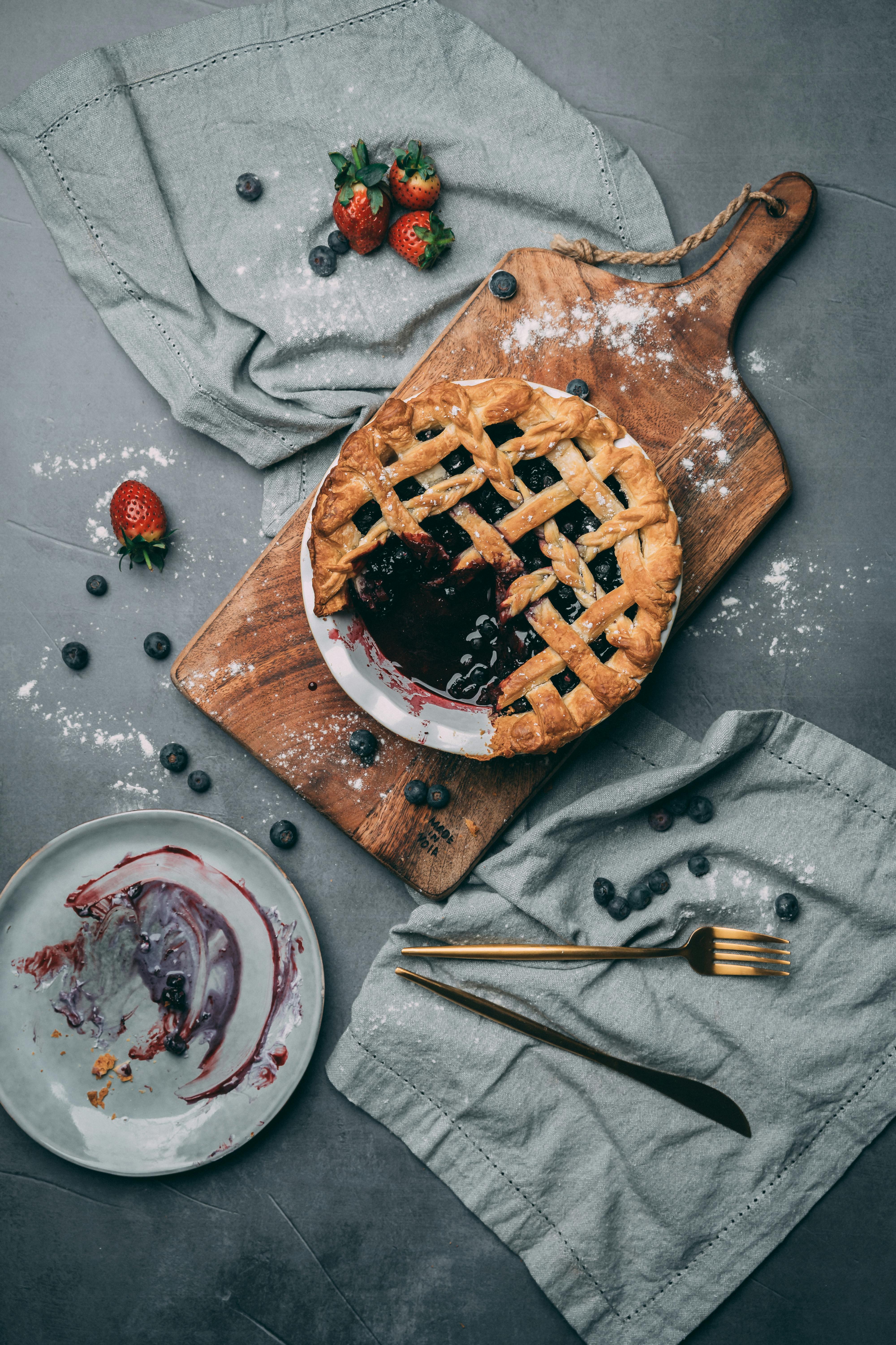 photo of berry pie on top of wooden chopping board