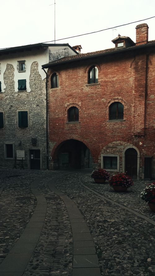 Free Exterior of aged pavement street with brick shabby buildings and potted plants in city Stock Photo