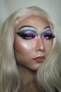 Person with bright shimmering makeup and dyed hair