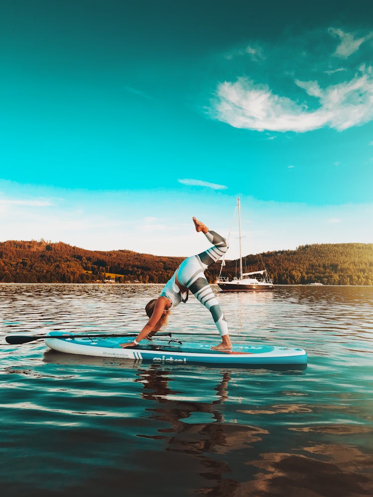 A Person Exercising On A Paddleboard Sailing On The Lake