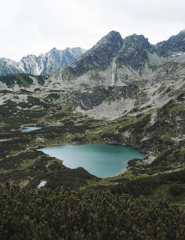 A breathtaking view of a serene mountain lake surrounded by rugged peaks in the Tatra Mountains of Poland.