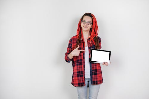 Slender female freelancer demonstrating tablet