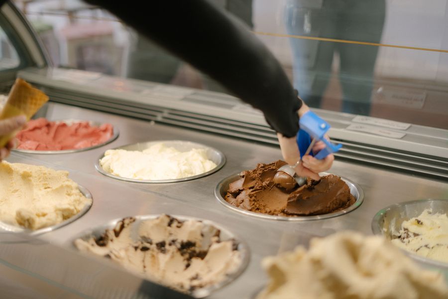 Scooping ice cream from the display case tubs