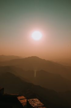 Beautiful sunrise casting silhouettes over Pune's serene mountains, showcasing nature's tranquility.