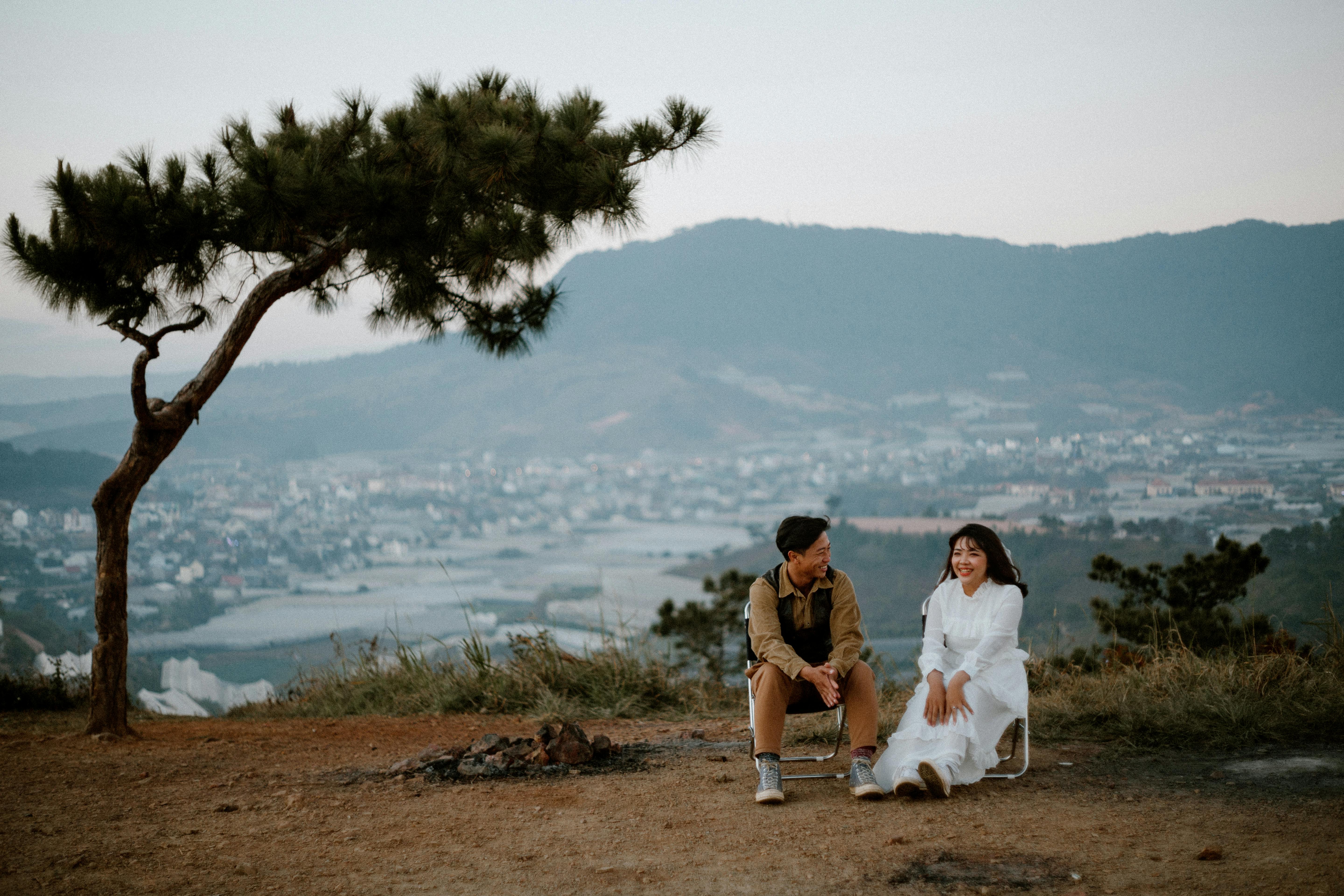 loving couple sitting on hill above city