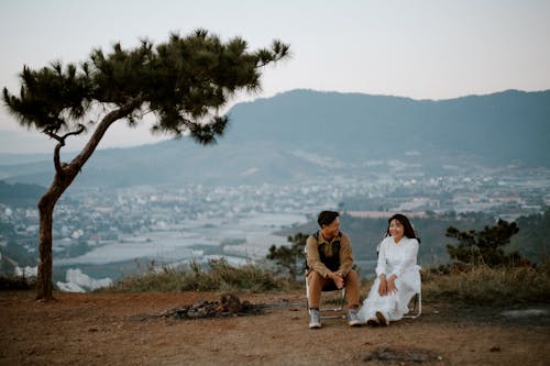 Loving couple sitting on hill above city
