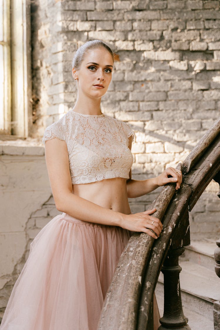 Woman In Lace Crop Top And Tutu Skirt Standing On The Stairs While Looking At The Camera