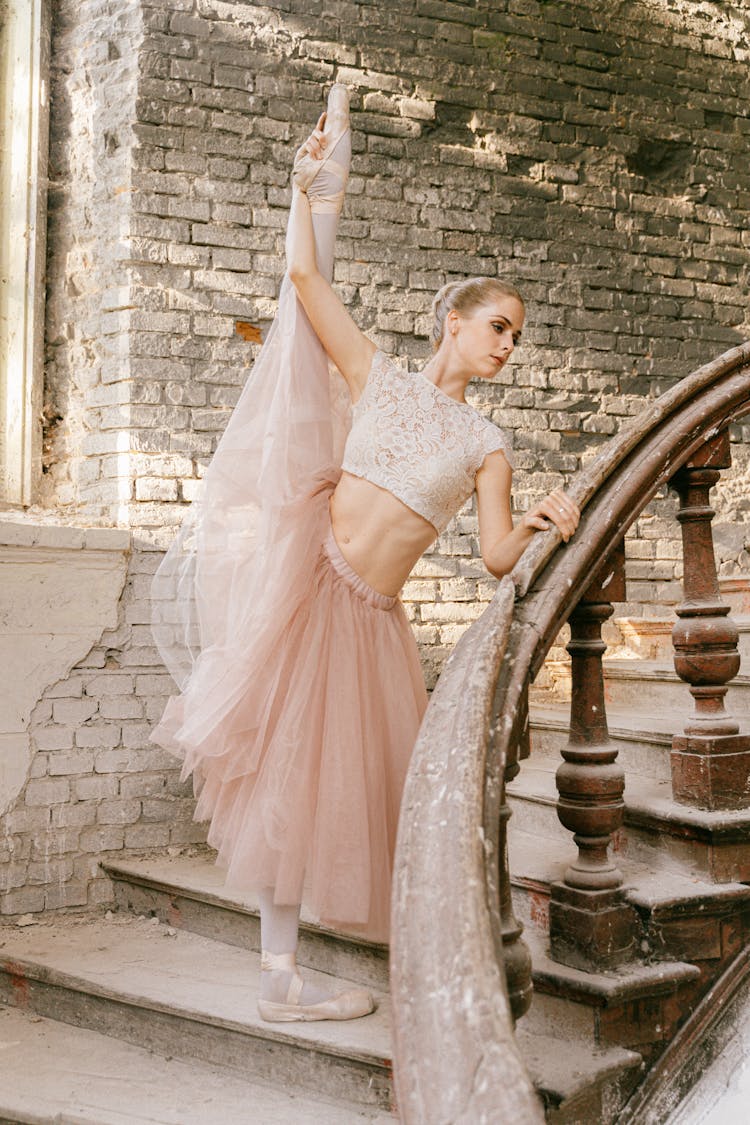 A Flexible Ballerina Standing On The Stairs