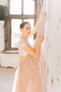 Woman in White Floral Dress Leaning on White Wall