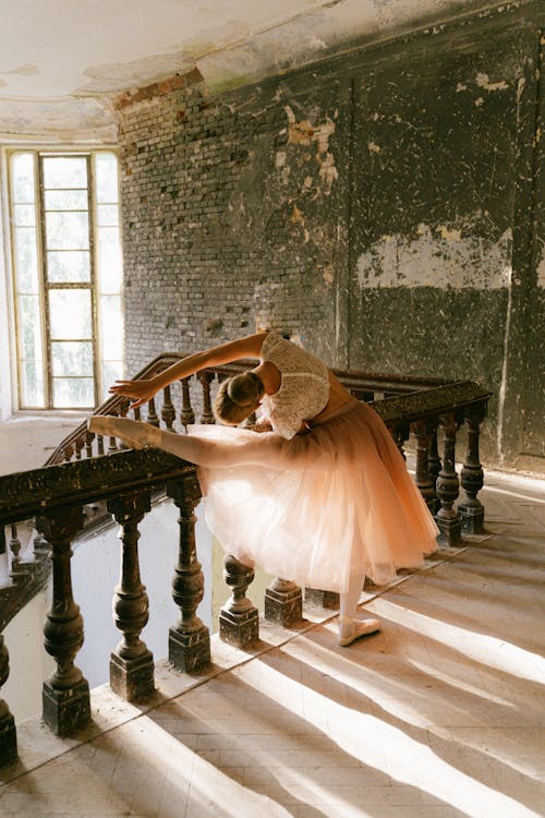 Back View Shot of a Ballerina Stretching Her Leg on a Concrete Railing