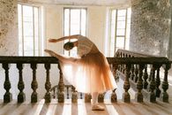 Woman in White Dress Standing on Brown Wooden Staircase