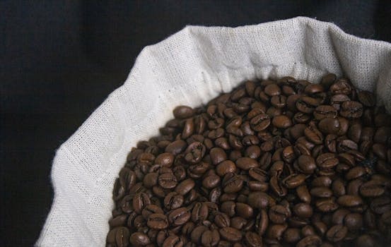 Rich, aromatic roasted coffee beans in a burlap sack providing a warm, cozy vibe.
