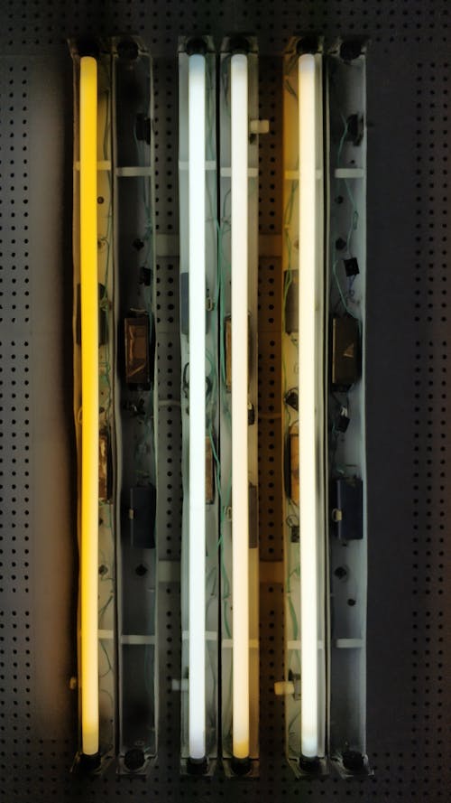 Switched on fluorescent lamps with light of different heat connected to mechanism on gray metal surface