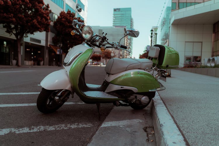 A Green Motor Scooter Parked On The Road