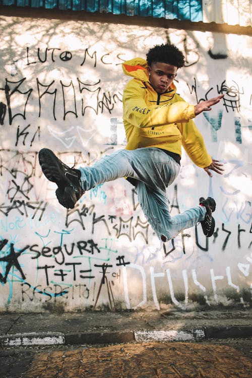 A Man in Yellow Hoodie Jumping