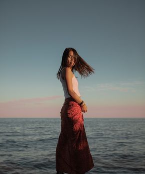 年轻女子在海边捕捉夏季自由的本质，享受宁静时刻