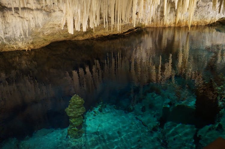 Stalactites Over Lake In Cave