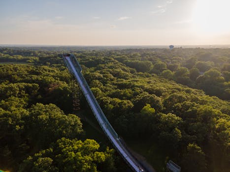 A panoramic aerial shot of a forest with a long water slide at sunset in Bloomington, Minnesota.