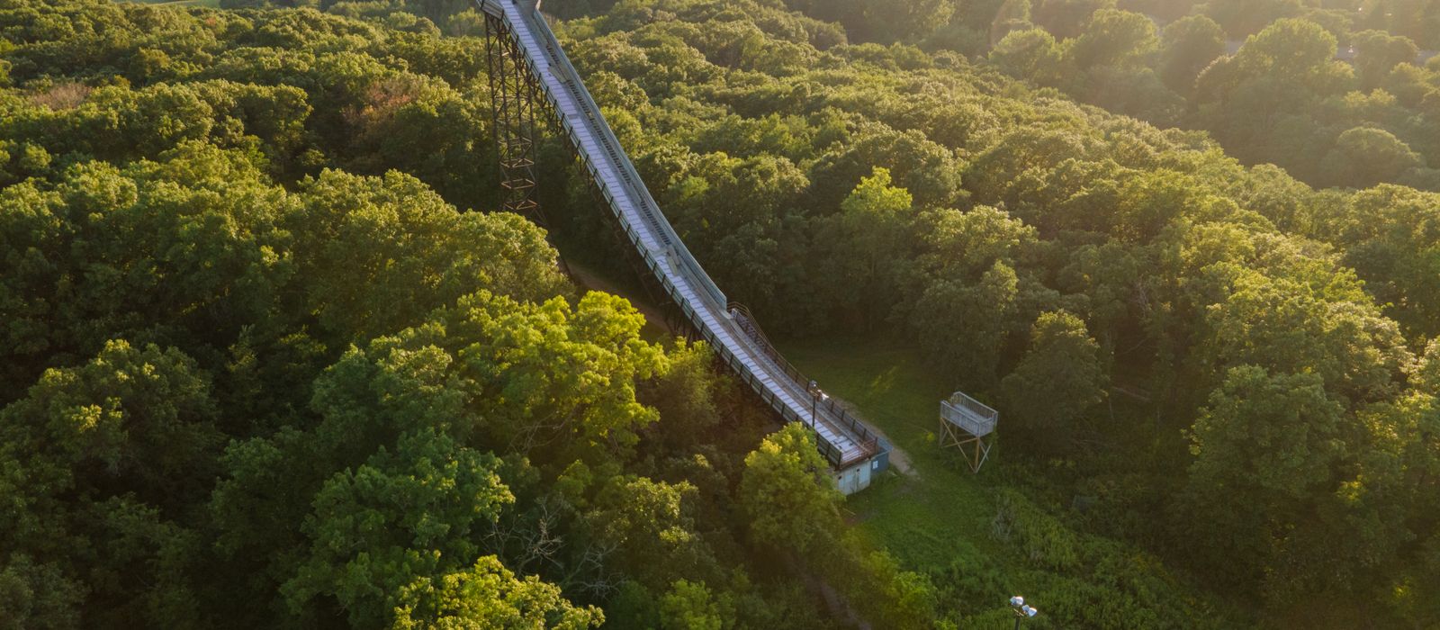 Aerial view of a slide surrounded by lush green forest in Bloomington, Minnesota during a sunny day.