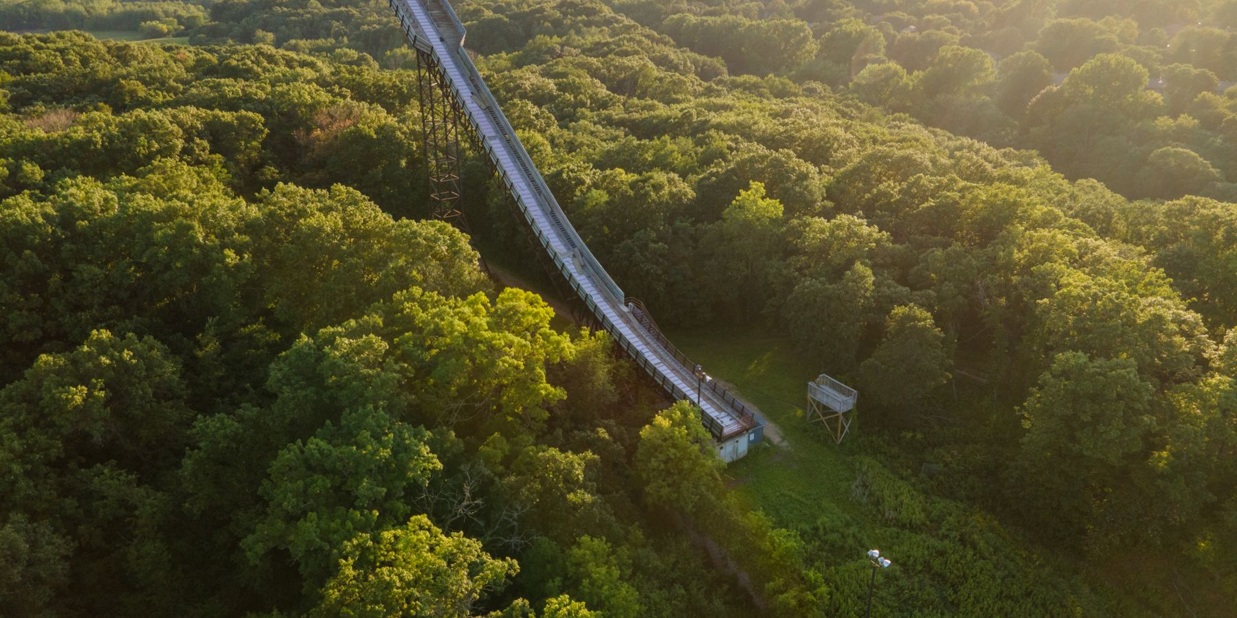 Aerial view of a slide surrounded by lush green forest in Bloomington, Minnesota during a sunny day.