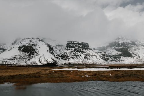 Pokryta śniegiem Góra W Pobliżu Zbiornika Wodnego