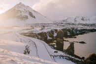 日出时分，冰岛白雪皑皑的沿海景观与山脉，捕捉着自然的美丽与宁静
