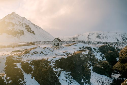 눈 덮힌 산 근처 눈 덮힌 땅에 흰색과 회색 집