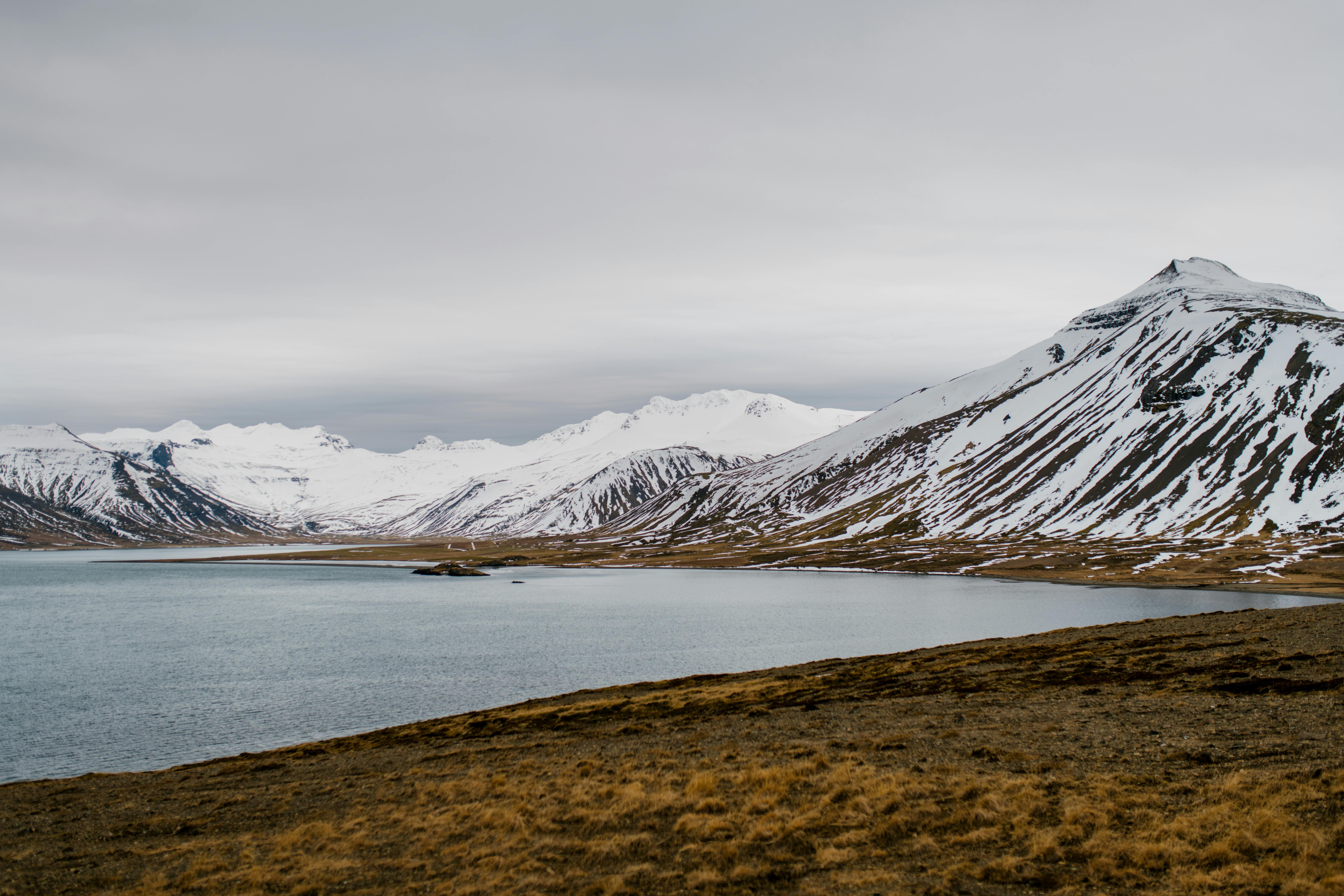 冰岛白雪皑皑的山脉与宁静的湖泊，展现出宁静的自然美景