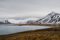 冰岛白雪皑皑的山脉与宁静的湖泊，展现出宁静的自然美景