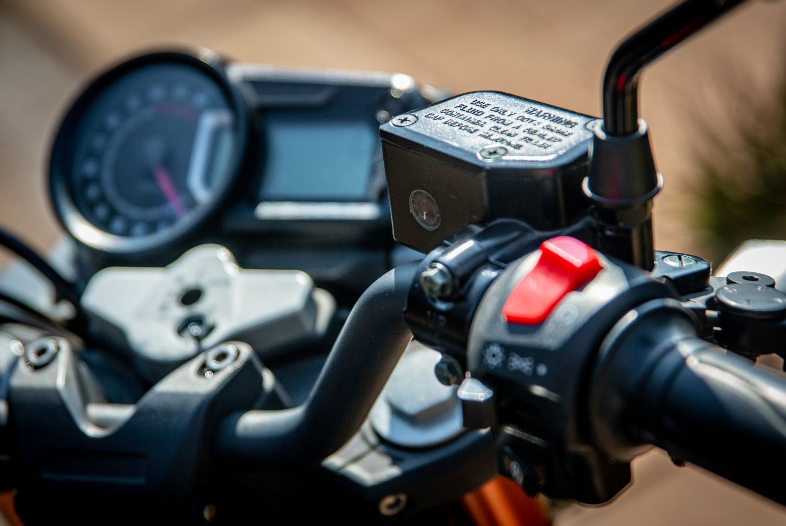 Vue rapprochée du guidon d'une moto avec les commandes et le compteur