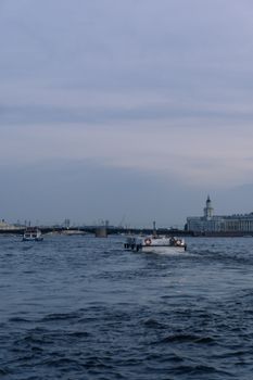 黄昏时分，在平静的天空下，宁静的河景、船只和历史悠久的城市景观尽收眼底