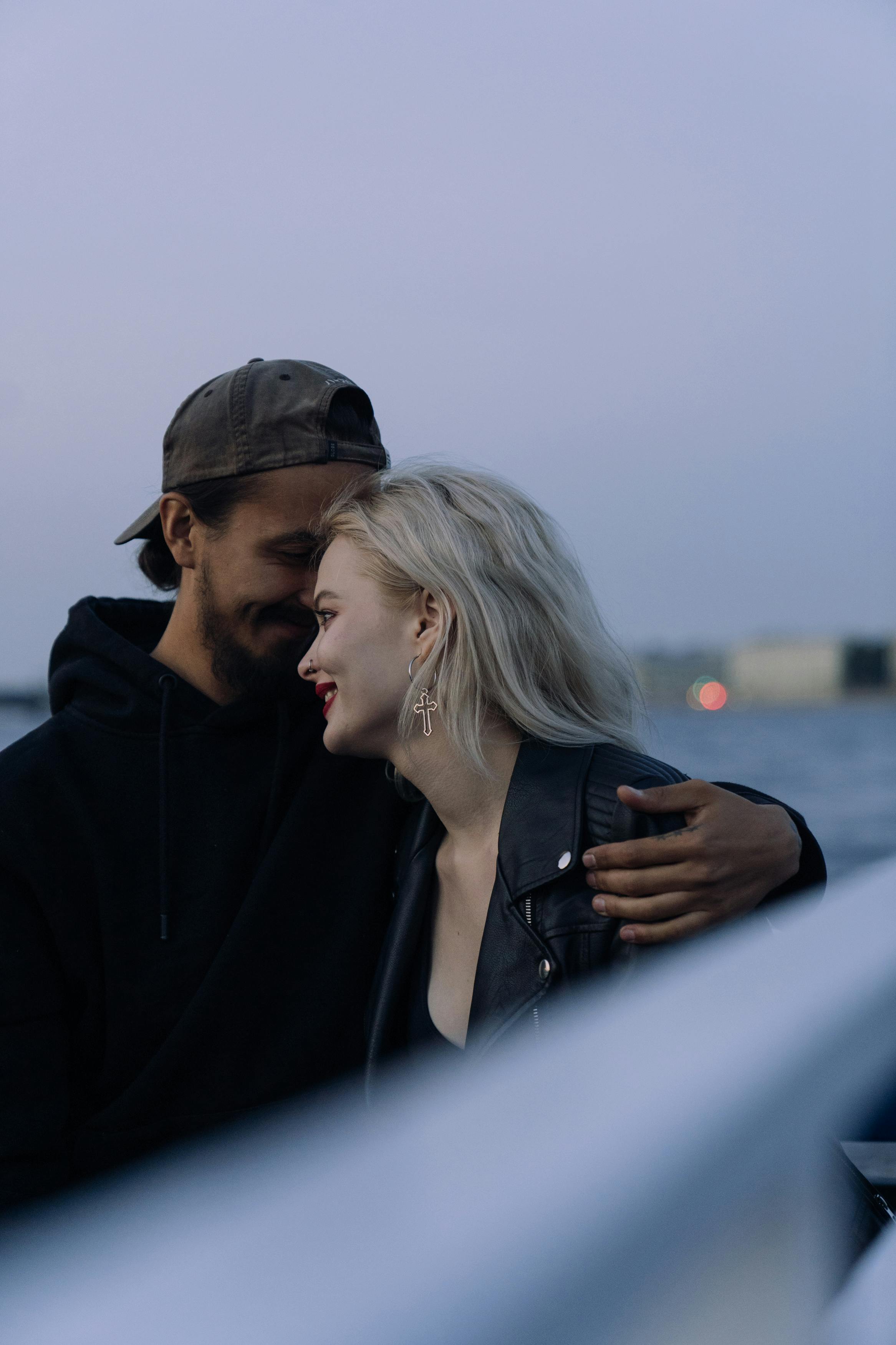 一对恩爱的夫妇乘船享受浪漫的夜晚，在宁静的水面上相拥