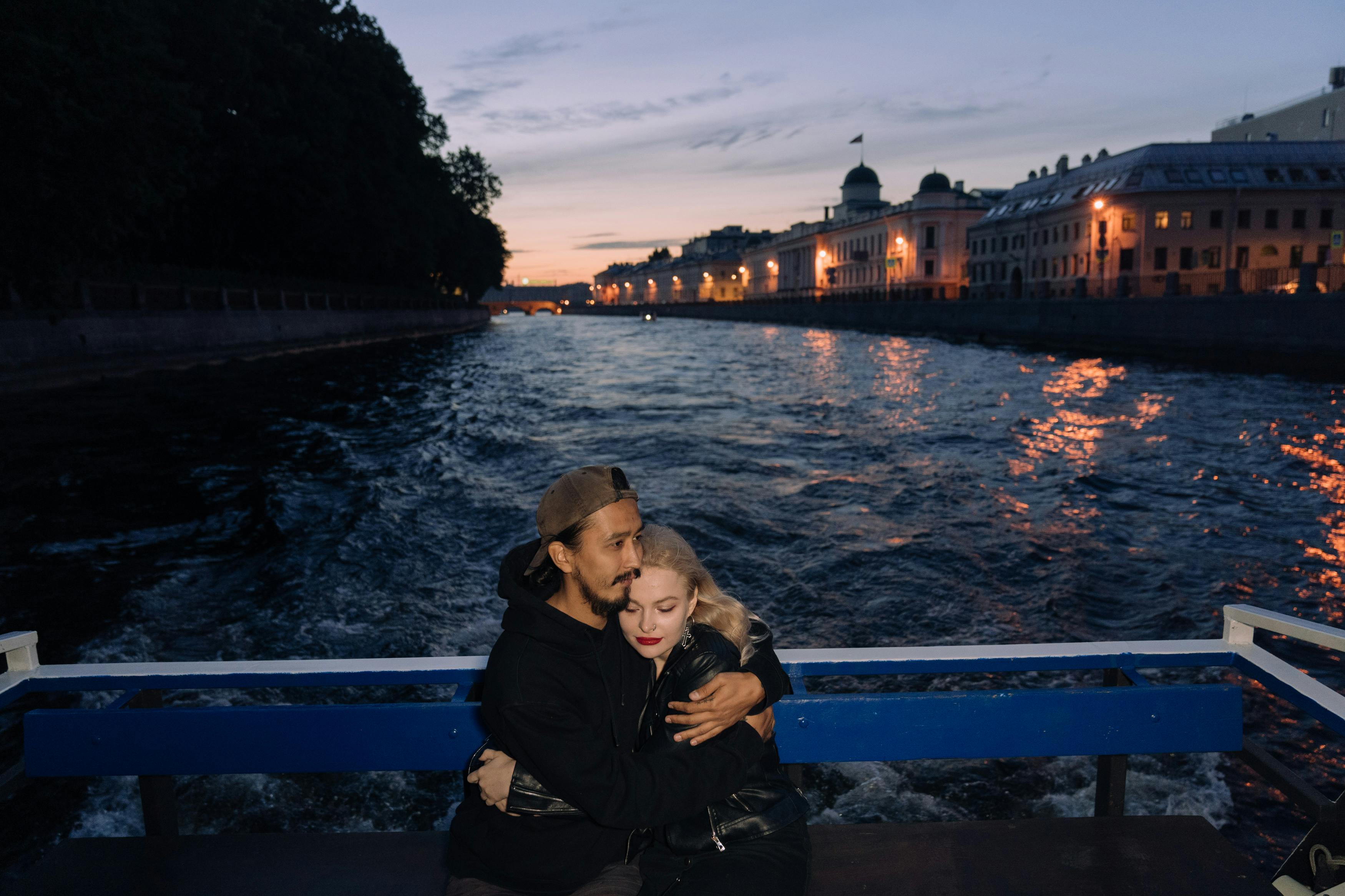 man in black jacket hugging woman in black jacket