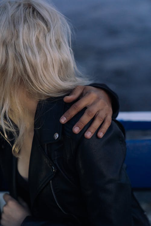 黑色皮夾克遮住她的臉，她的手的女人